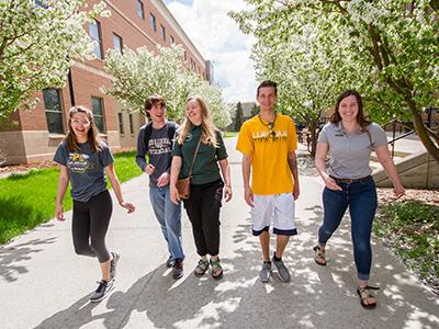 Five students walk around campus.